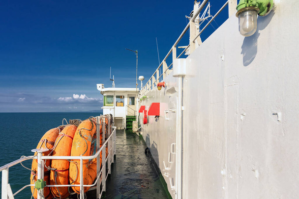 緊急事態や海上事故のためのフェリーデッキのオレンジインフレータブル救命ボート。救助艇、フェリーの屋根の上のいかだ。海上クルーズ船の大型船での救命ボート輸送と安全. - 写真・画像
