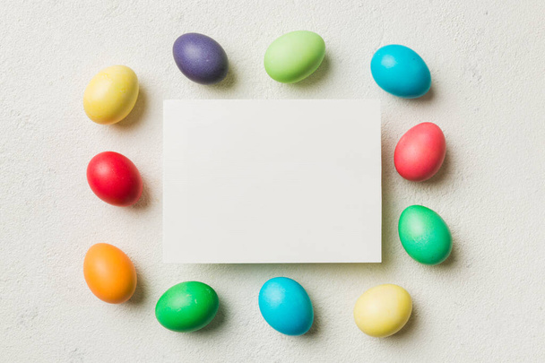 round frame multicolored Easter eggs with white blank paper on a brown background, close-up, space for text, blank for design, selective focus, tinted image. - Photo, Image