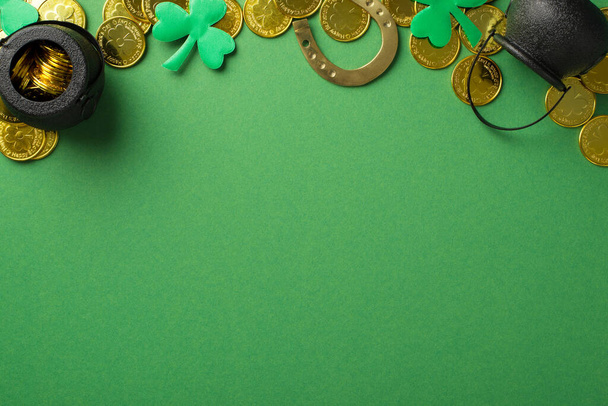 Top view photo of the many golden coins two black pots with money bronze horseshoe and confetti in shape of clovers at the top of the green empty isolated background - Valokuva, kuva