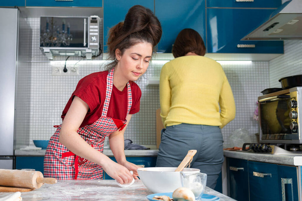 Kotiruokaa ja LGBT parit käsite. Kaksi kaunista nuorta naista valmistaa ruokaa yhdessä keittiössä.. - Valokuva, kuva