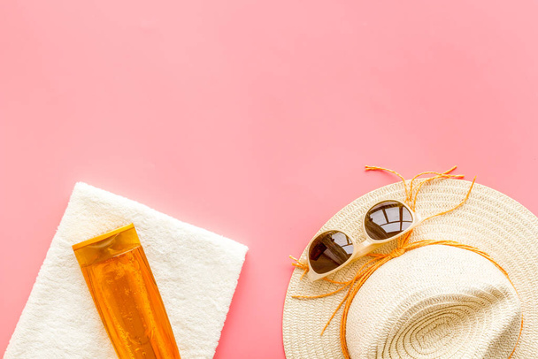 Концепция летнего пляжного отдыха с соломенной шапкой и бутылками солнцезащитного крема - Фото, изображение