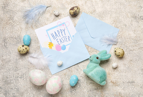 Beautiful Easter composition with greeting card, painted eggs and bunny on grey background - Valokuva, kuva