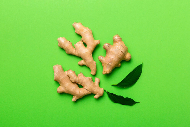 Finely dry Ginger powder in bowl with green leaves isolated on colored background. top view flat lay. - Photo, Image