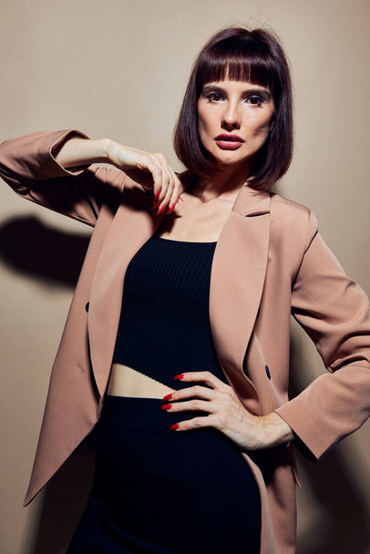 attractive woman in a beige jacket elegant style posing Lifestyle unaltered - Foto, afbeelding