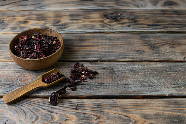 Brewing from rosella flowers in a wooden bowl on a light brown wooden table - Fotoğraf, Görsel