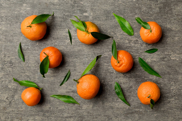 Viele frische reife Mandarinen als farbiger Hintergrund, Draufsicht. Eleganter Hintergrund aus Clementinen und Mandarinenscheiben. - Foto, Bild