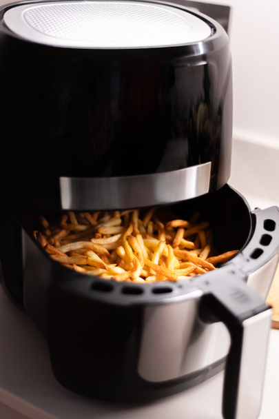 Frituurpan met frites op het werkblad - Foto, afbeelding