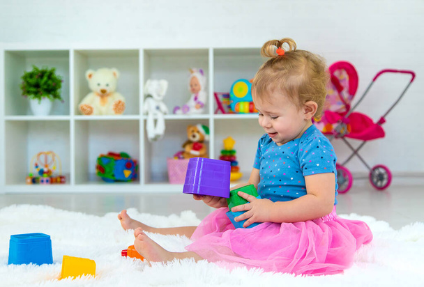 A baby child plays with toys in the playroom. Selective focus. Kid. - Foto, Bild