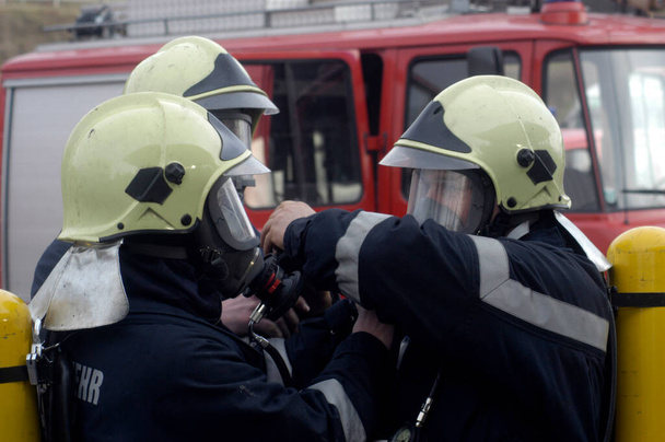 firefighter wearing protective clothing and respirator mask against flue gas - Photo, Image