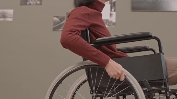 Recortado slow shot de usuario de silla de ruedas irreconocible en exposición en galería de arte contemporáneo - Metraje, vídeo