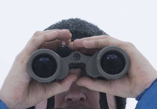 una persona mirando a través de prismáticos para ver objetos lejanos - Foto, imagen