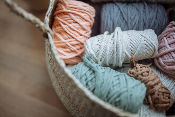 Beige wicker basket with multi-colored macrame threads. Close-up of threads - 写真・画像
