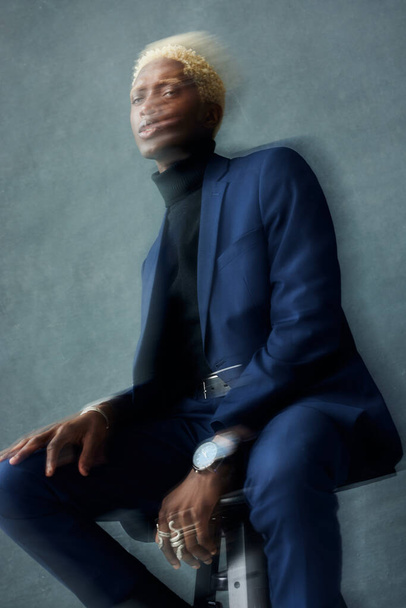 dark-skinned guy in a dark suit sitting on a chai - Foto, Imagem