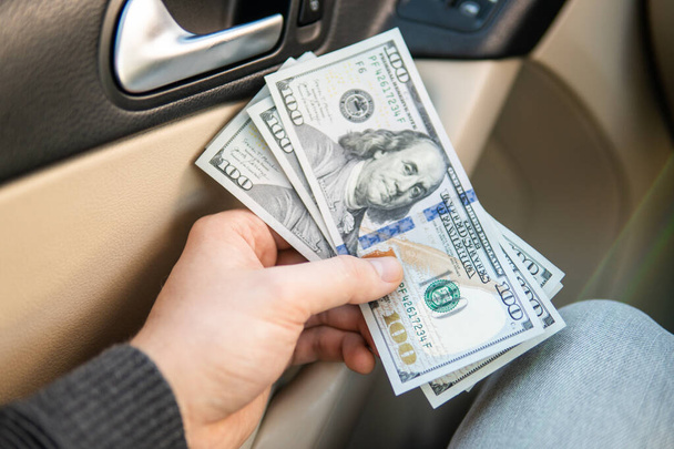 Businessman Person holding a wallet in the hands of take money out of pocket in car prepare pay by installments - insurance, loan and buying car finance concept insurance, payment a car - Photo, Image