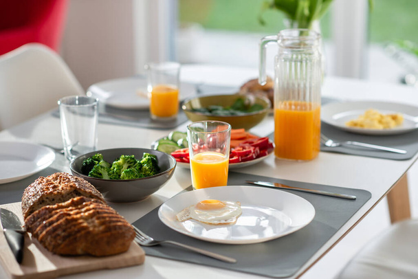Breakfast closeup with eggs, wholegrain bread, green fresh broccoli, and orange juice - Photo, image