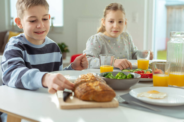 Teen children having healthy breakfast at home in the morning before school - Photo, image