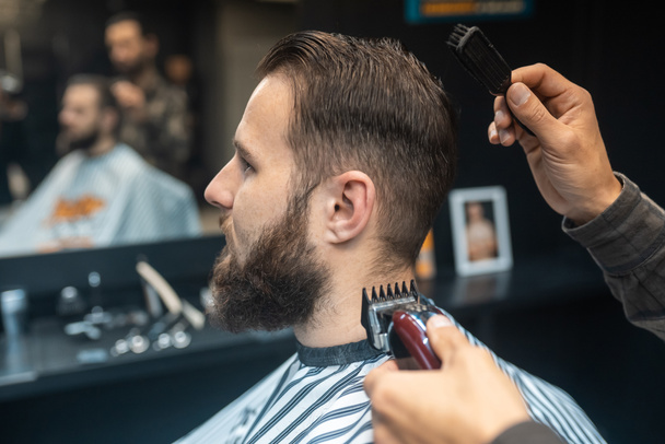 Master in barbershop makes mens haircutting with hair clipper - Foto, Imagem