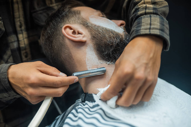 jovem barbudo homem chegando barbeado por cabeleireiro no barbearia - Foto, Imagem