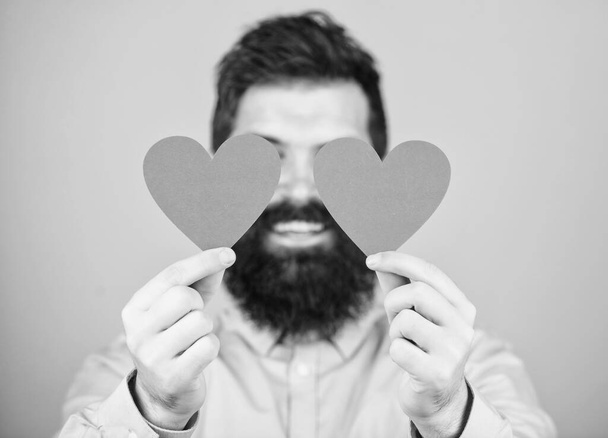 That is love. Sexy valentine man covering eyes with love cards. Bearded man holding red hearts. Hipster with small hearts. Happy valentines day. Expressing his love - 写真・画像