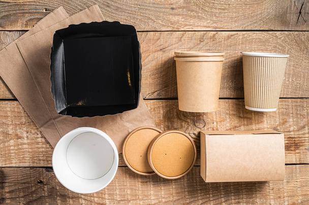 Disposable paper tableware. Eco friendly Recycling set of paper cups, dishes, bag, fast food containers and cutlery. Wooden background. Top view. Copy space - Foto, Bild
