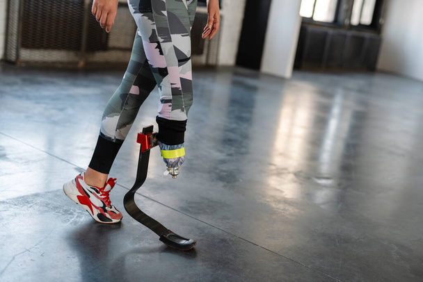 Young sportswoman with prosthesis working out indoors - Foto, Imagem