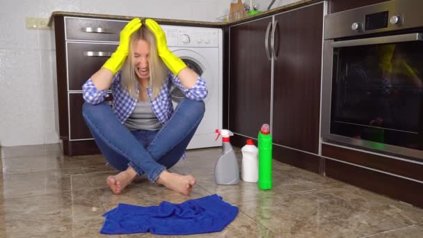 Una mujer enojada grita, cansada de limpiar, se pone guantes de goma - Metraje, vídeo