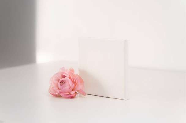 Mockup empty frame paper card with pink flower on white background, minimalism concept. Copy space, place for text or your design. - Foto, imagen