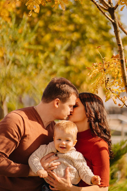 a portrait of happy family with a small child on an autumn walk.  - Φωτογραφία, εικόνα