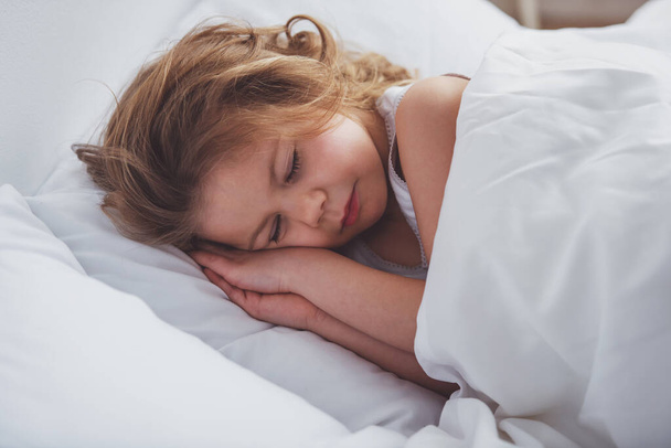 Douce petite fille dort dans son lit à la maison, gros plan
 - Photo, image