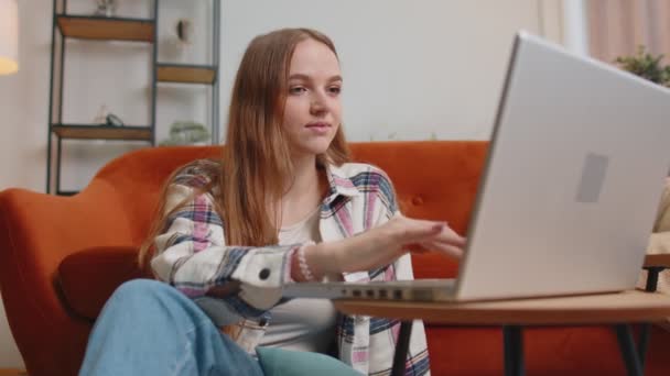 Junge Frau mit Laptop am Boden sitzend, Online-Shopping vom Home Office aus - Filmmaterial, Video