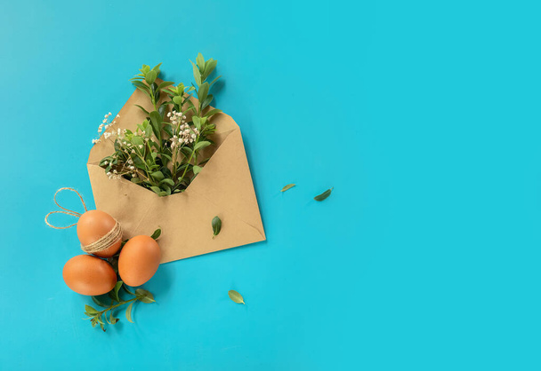 easter eggs with greenery in an envelope, copy space for text, promo or message. easter greeting or sale concept. High quality photo - Fotografie, Obrázek