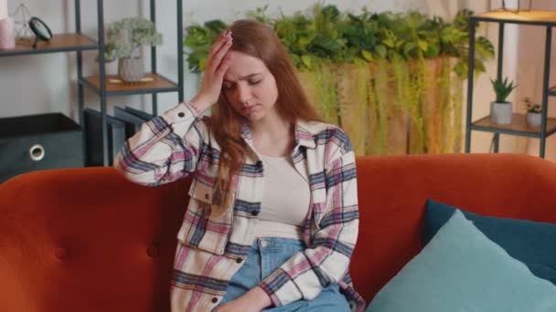 Mujer joven disgustada frotando las sienes para curar el problema del dolor de cabeza, que sufre de tensión y migraine - Imágenes, Vídeo