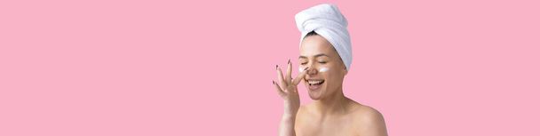 Beauty portrait of woman in white towel on head applies cream to the face. Skincare cleansing eco organic cosmetic spa relax concept. - Zdjęcie, obraz