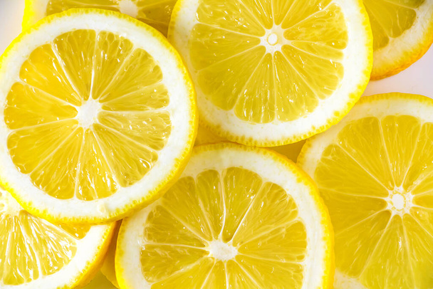 Свежие сочные лимоны крупным планом. Спелые желтые цитрусовые ломтики. - Фото, изображение