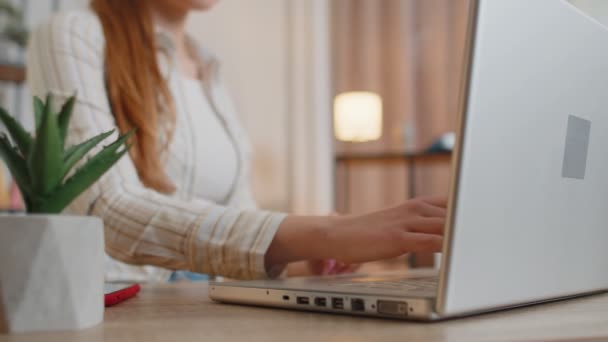 Jeune fille à l'aide d'un ordinateur portable assis à la table de travail, tapant sur le clavier de bureau à domicile - Séquence, vidéo