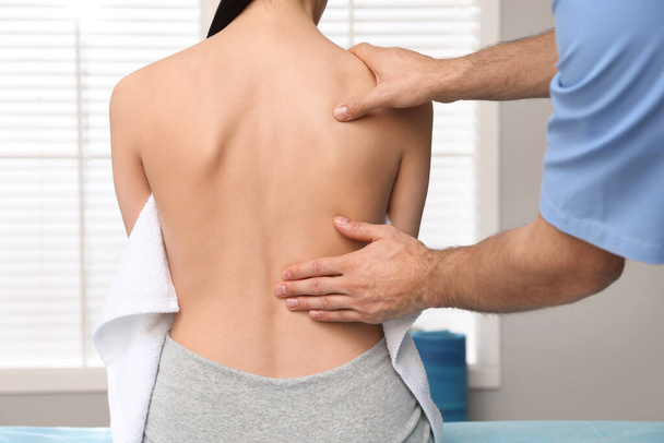 Orthopedist examining woman's back in clinic, closeup. Scoliosis treatment - Fotografie, Obrázek