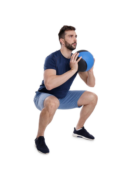 Athletic man doing squats with medicine ball isolated on white - Fotografie, Obrázek