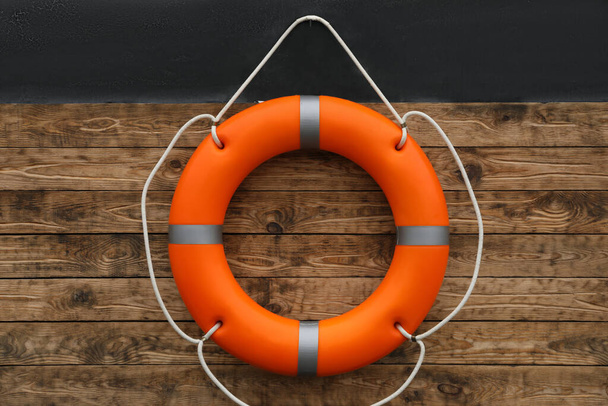 Orange lifebuoy hanging on wall. Rescue equipment - Фото, зображення