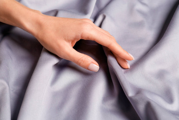 Woman touching soft silver fabric, closeup view - Foto, Imagen