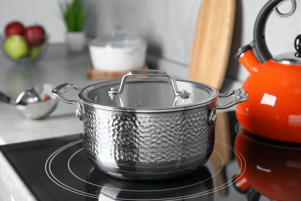 Pot with lid on cooktop in kitchen. Cooking utensil - Foto, imagen