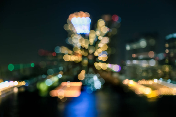 Unschärfe der Stadt bei Nacht mit hellem Bokeh und Wasserreflexion Hintergrund - Foto, Bild