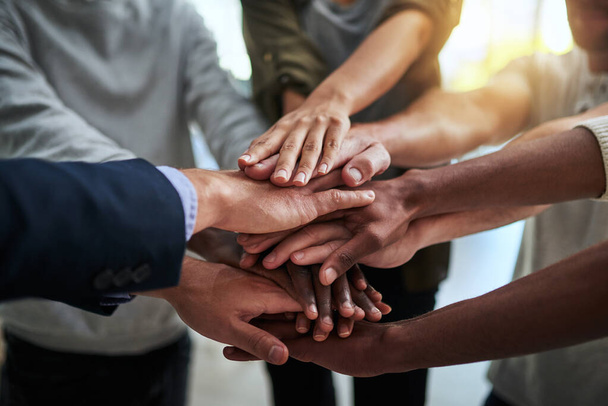 Theres nothing we cant do together. Cropped shot of a group of businesspeople joining their hands in solidarity. - Foto, imagen