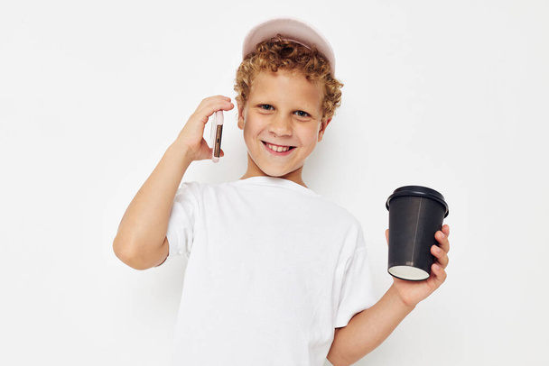 Cute little boy what kind of drink is the phone in hand communication light background unaltered - Fotó, kép