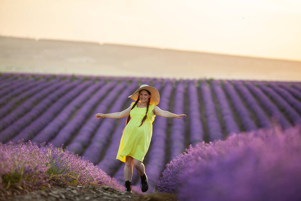 pregnant Woman in lavender flowers field at sunset in yellow dress. - Fotografie, Obrázek
