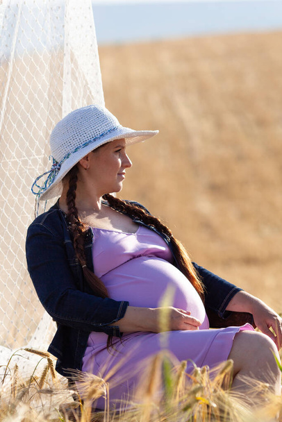 pregnant woman in a wheat field - Foto, afbeelding
