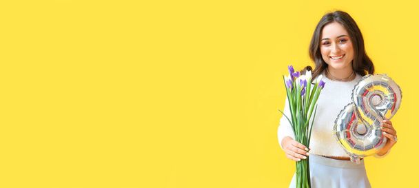 Happy woman holding iris flowers and balloon in shape of figure 8 on yellow background with space for text. International Women's Day - Photo, Image