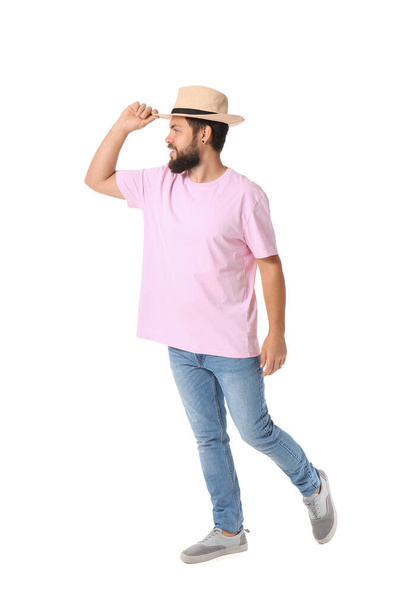白い背景にピンクのTシャツの帽子を持つハンサムな男 - 写真・画像