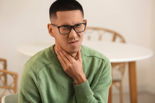 Malade asiatique homme avec mal de gorge à la maison - Photo, image