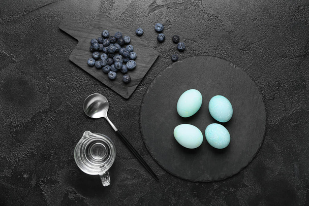 Natural dyed Easter eggs and blueberry on dark background - Foto, imagen