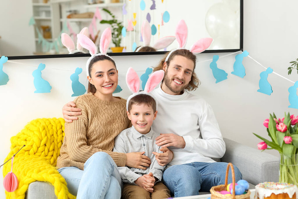 Щасливі батьки зі своїм маленьким хлопчиком у вухах кролів у Великдень - Фото, зображення